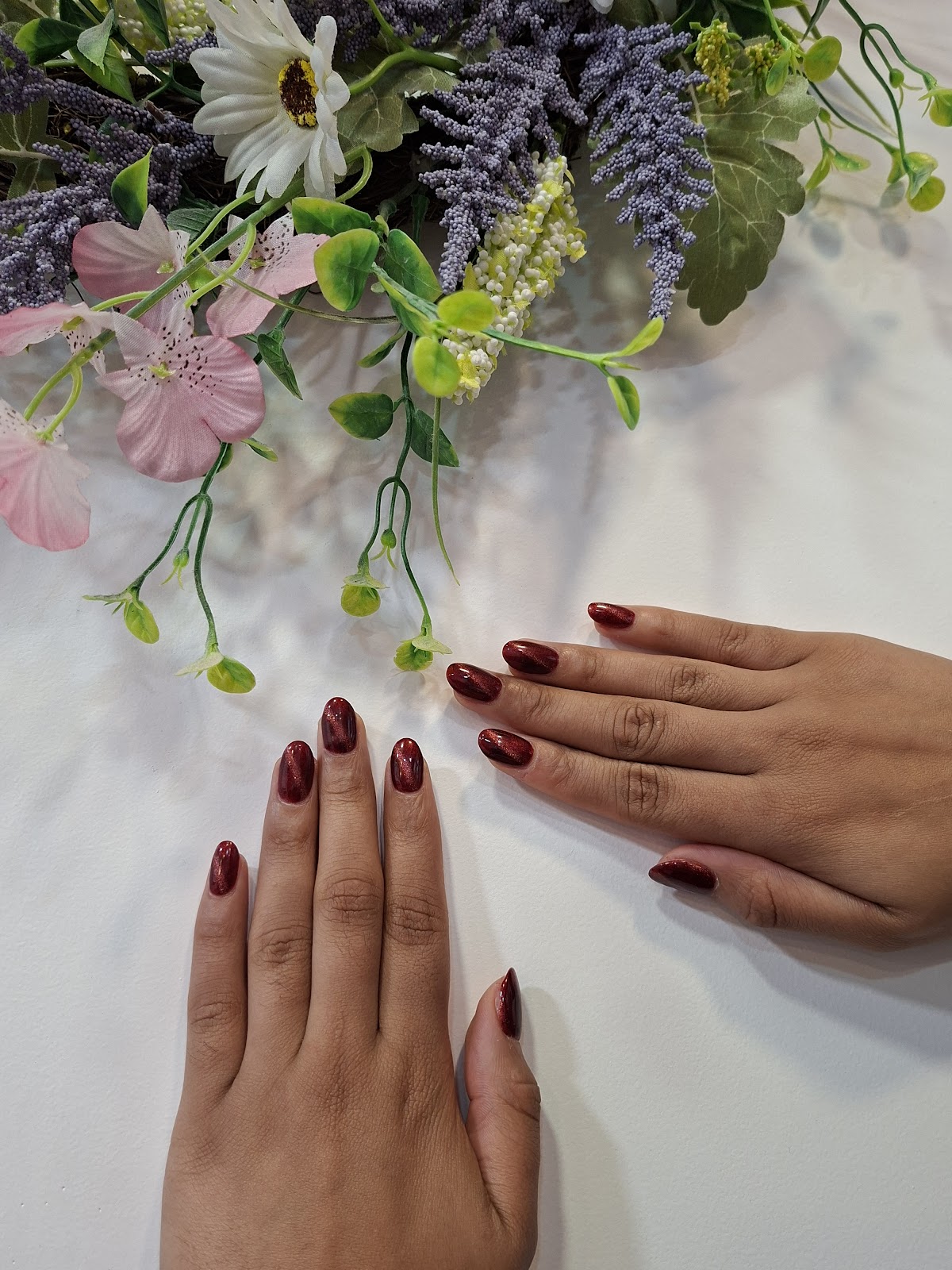 Ongles vernis rouge bordeaux, décorés de fleurs lavande et roses